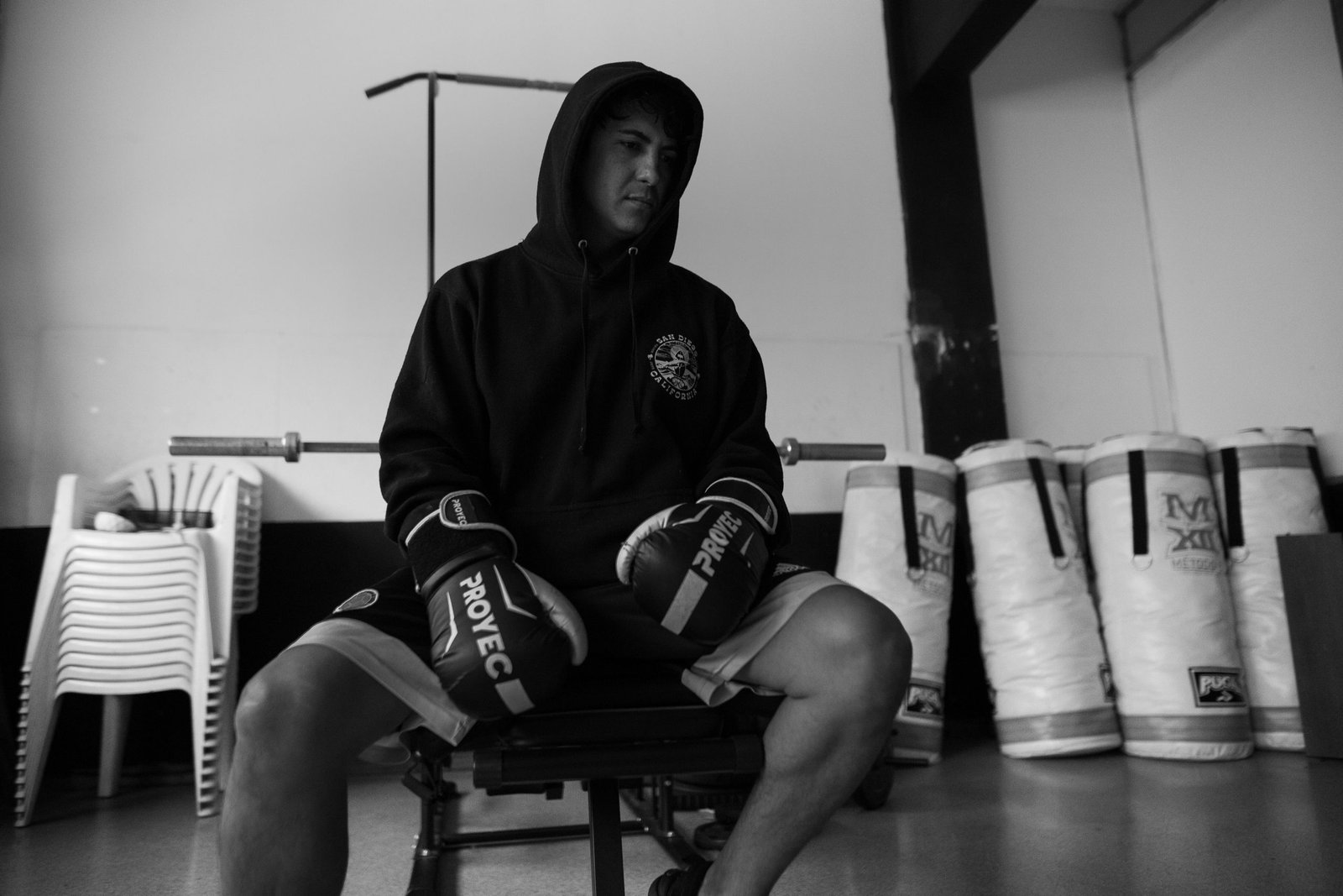 Black and white photo of a boxer sitting in a gym in Buenos Aires, showing determination.